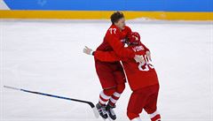 Kirill Kaprizov (vlevo) slaví zlatý olympijský gól se spoluhráem Vojnovem.