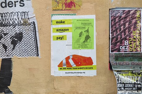 Plakát levicových antiglobalistů v Drážďanech kritizuje společnost Amazon,...