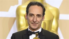 Alexandre Desplat se usmívá nad svým Oscarem za nejlepí pvodní hudbu. Za to...