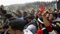 Palestinští demonstrující evakuují raněnou mládež.