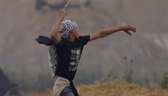Palestinský protestant vrhá kameny proti izraelským vojákm.