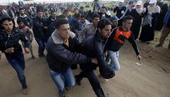 Palestintí protestující evakuují své ranné.