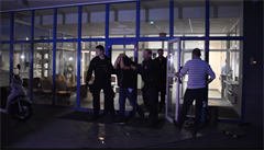 Policie odvádí jednoho z Nizozemc, obvinných z napadení íníka v Praze.