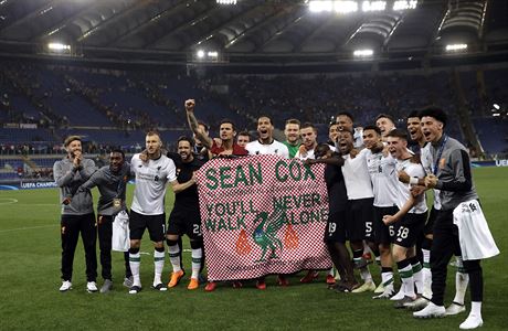 Liverpoolští hráči s transparentem na podporu Seana Coxe, kterého napadli před...