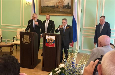Ruský velvyslanec Alexandr Zmejevskij (u pultu vpravo) si pipíjí na oslav Dne...