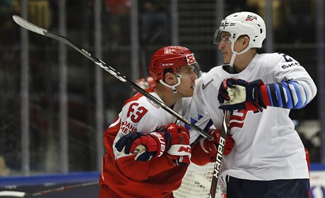 Dánský hokejista Patrick Russell vlevo v souboji s  Tageem Thompsonem z USA p�i...