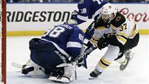 Centr Bostonu Bruins Patrice Bergeron (v blm) zakonuje pi utkn s Tampou v...