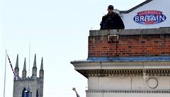Ozbrojený policista stojí na střeše domu nedaleko hradu Windsor.