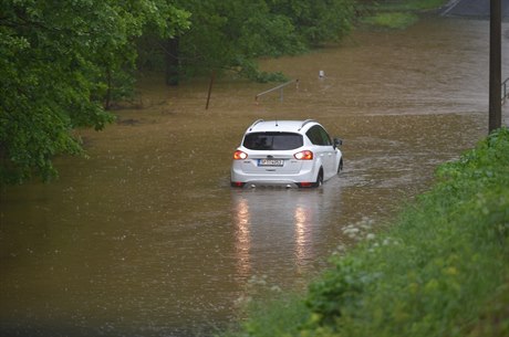 Auto na zaplavené silnici.