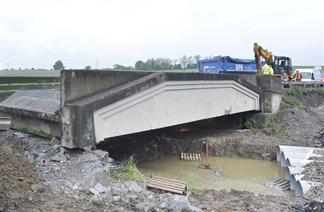 Stavbai naváejí trk na most na silnici 1/26 mezi obcemi Holýov a Stakov...