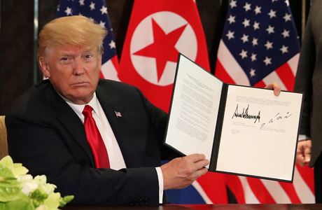 Prezident Trump ukazuje podepsané prohláení.