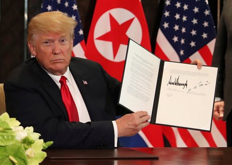 Prezident Trump ukazuje podepsané prohlášení.