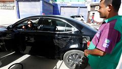 Mu na benzínové pump pomáhá ena natankovat její auto.