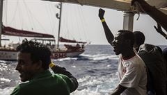 Zachránní migranti jásají na palub lodi organizace Proactiva Open Arms.