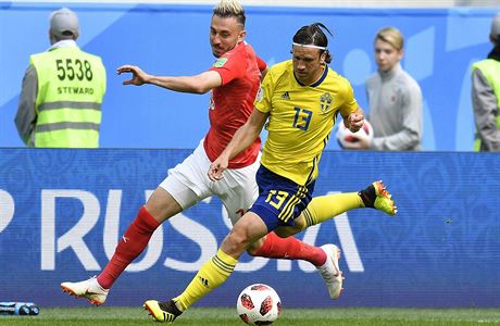 MS ve fotbale 2018: véd Gustav Svensson (vpravo) a výcar Blerim Dzemaili v...