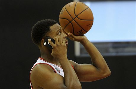 Basketbalista Toronta Kyle Lowry sleduje mobil i pi rozcvice ped zápasem.