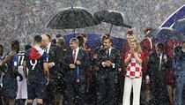 Zatímco prezidenti Vladimir Putin a Emanuel Macron jsou schováni pod deštníkem,...