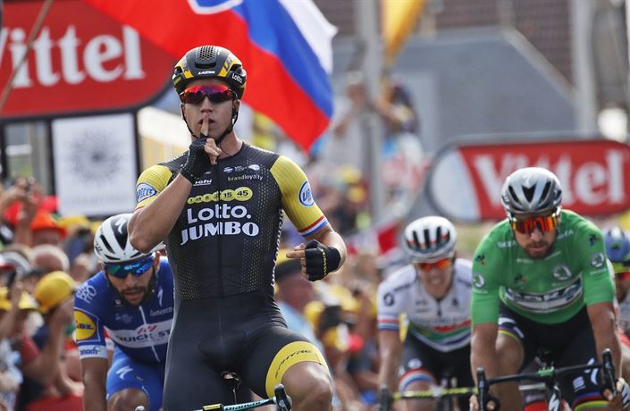 Dylan Groenewegen se raduje v pozadí se slovenskou vlajkou.