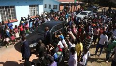Bývalý prezident Zimbabwe Robert Mugabe jde volit obklopen svými podporovateli.
