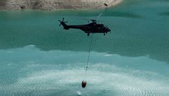 Helikoptéry Super Puma transportují vodu v zavených ervených plastických...