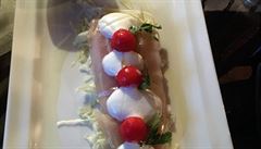 Ryba s kousky melounu a bazalkovou zmrzlinou servírovaná na zelí v restauraci,...