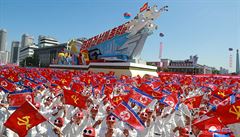 Vlajky Severní Koreji a obrovské alegorické vozy.