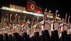 Mladí Severokorejci a vlajka zem v pozadí.