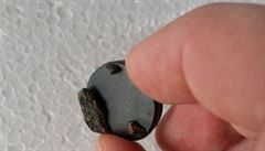 Úlomky meteoritu pichycené na magnetu.