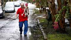 Mu kráí se svým psem v náruí po úderu hurikánu Florence.