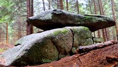 Lesní cestika vás zavede a ke skalnímu útvaru, kdy se velký placatý kámen...