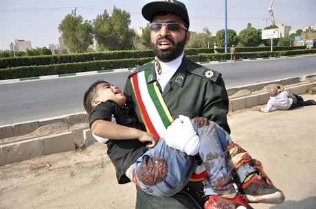 Voják odnáí zranné dít po útoku na vojenské pehlídce v íránském Ahvázu.
