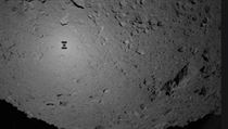 Obrys japonsk sondy Hayabusa 2 nad asteroidem Ryugu.