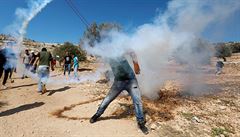 Jeden z Palestinc odhazuje zpt kanystr se slzným plynem, jím Izraelci...