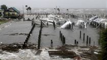 Storm Surge retreats from inland areas, foreground, where boats lay sunk and...