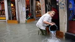 ena vylévá kýble s vodou ze svého obchodu v centru Benátek.