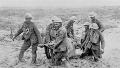 Kanadtí vojáci nesou nosítka se zranným skrze bláto. Snímek z roku 1917...