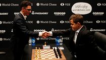 Fabiano Caruana (vlevo) si třese rukou s Magnusem Carlsenem před prvním...