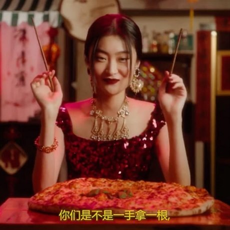 íanka konzumující pizzu hlkami v reklamním spotu znaky Dolce&Gabbana.