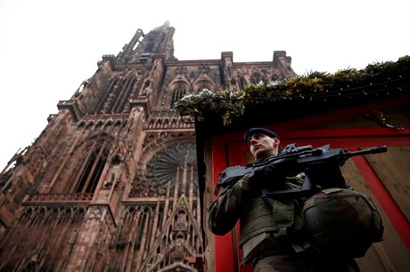 Voják hlídkuje u vánočních stánků před katedrálou ve Štrasburku.