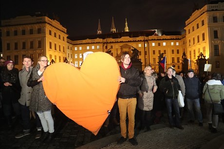 Účastníci pochodu k uctění památky Václava Havla se srdcem před Pražským hradem.