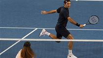 Švýcar Roger Federer vrací míček přes síť k Sereně Williamsové.
