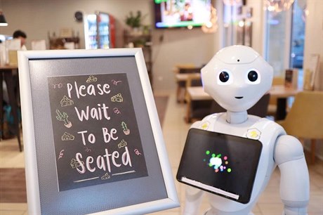 Robotičtí číšníci a servírky vysocí přibližně jako šestileté dítě se v kavárně...