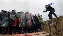 Jeden z protestujících útoí na policejní tkoodnce.