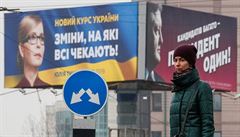 Ukrajinu navíc brzy ekají volby. Zde ena stojí ped pedvolebními plakáty...