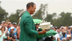 Tiger Woods se zeleným sakem a trofejí pro vítze.
