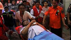 Záchranái peváí ranného po havárii letadla v Barm.