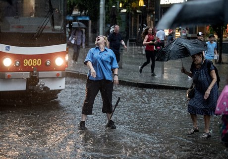 Řidička tramvaje se snaží v prudkém dešti přehodit výhybku.