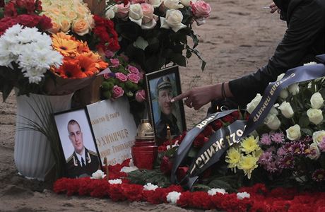 A mourner touches a photograph at the grave of Captain third rank Vladimir...