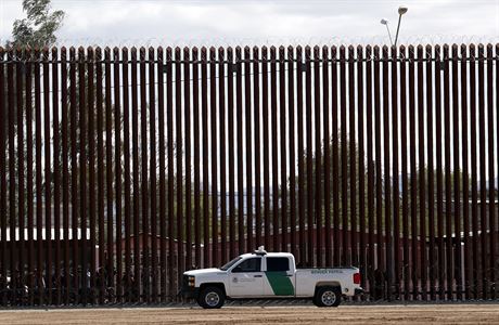 Americký celní a pohraniní vz vedle hraniní zdi mezi USA a Mexikem.