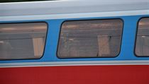 Pokozen okno pmstskho vlaku, na nj patrn kdosi mezi praskm...